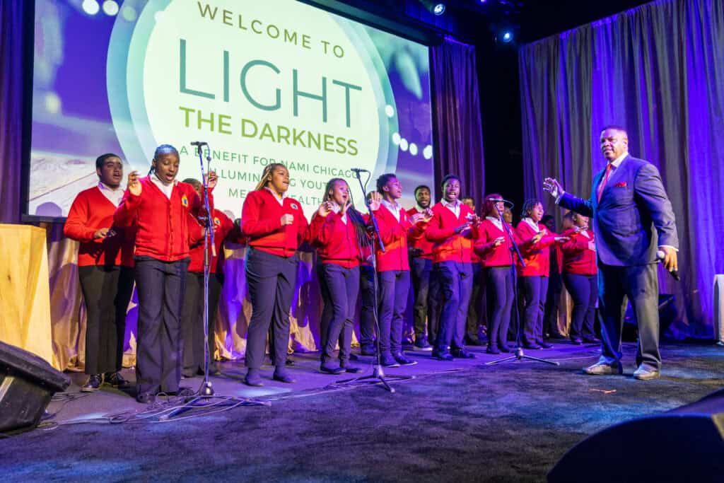 Youth choir performing on stage at the “Light the Darkness” benefit for NAMI Chicago, a mental health awareness event featuring live music, community engagement, and impactful nonprofit programming.