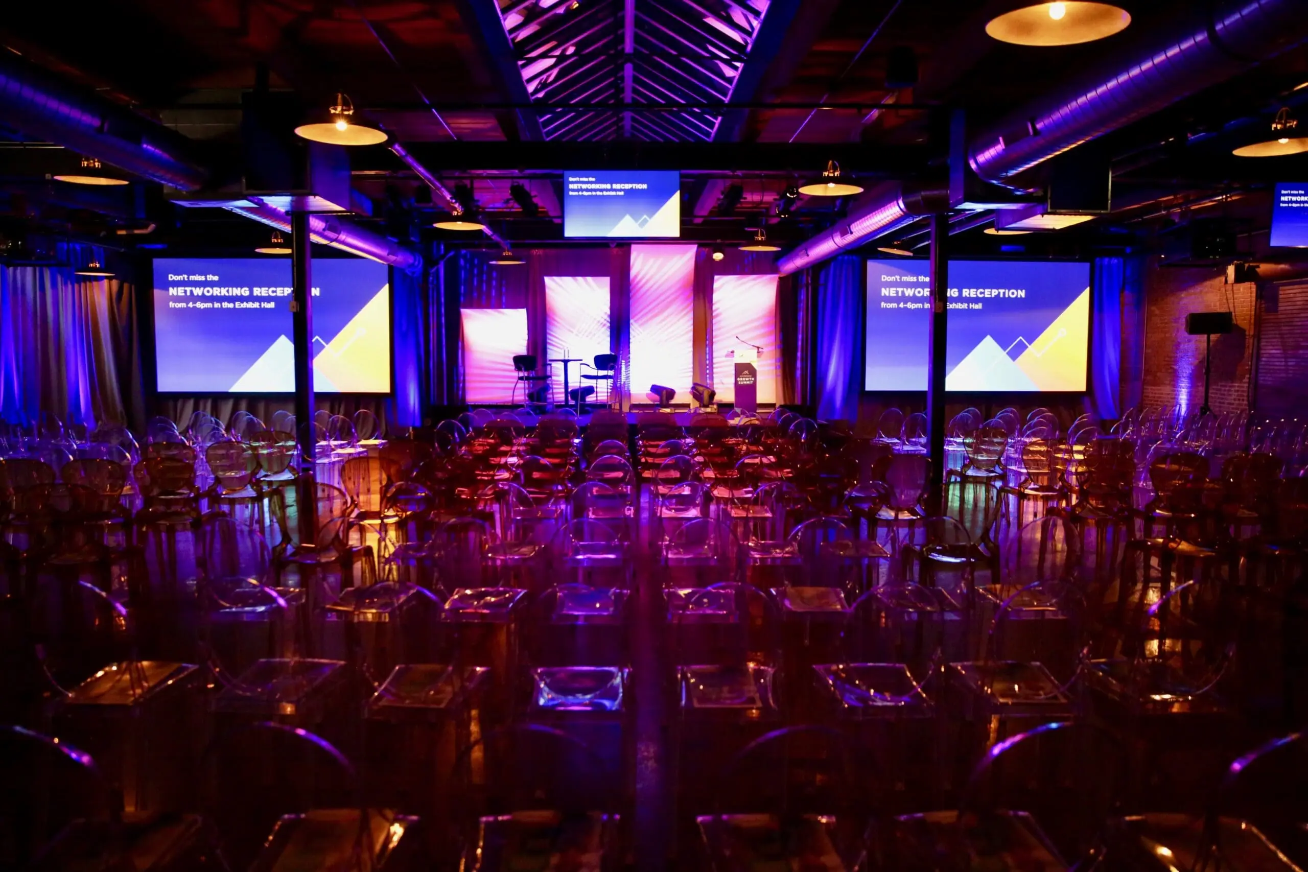 Large room with purple lighting and chairs, set up for an event by a Chicago event planner.